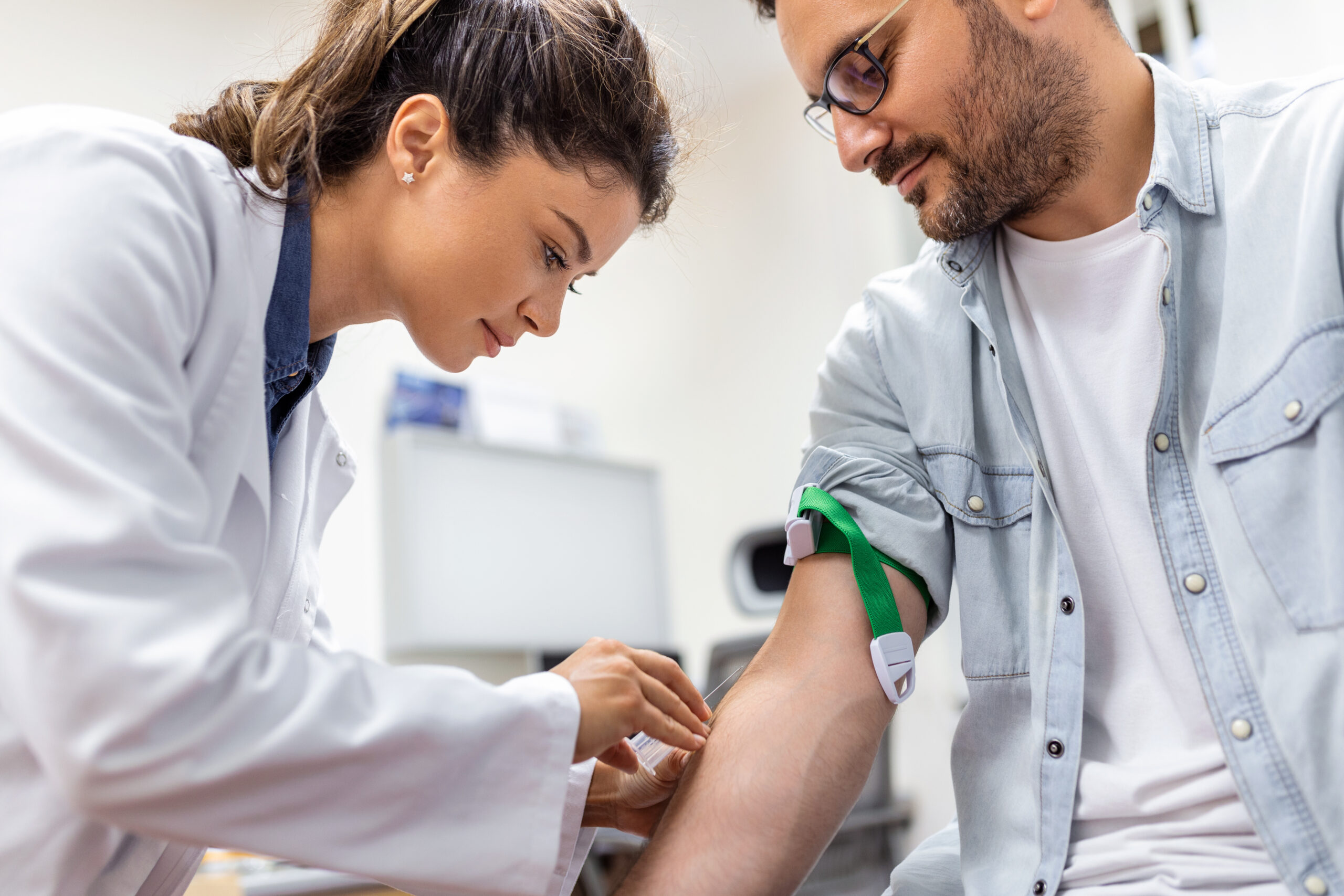 A female doctor collecting blood sample from a male patient